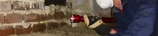 Pest control technician inspecting a crawl space for ant activity and entry points in Kansas City, MO