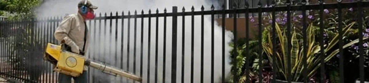 Mosquito control technician fogging a yard perimeter for mosquito reduction in Kansas City, MO